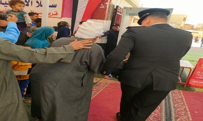 رجال الأمن بالفيوم يقدمون المساعدة لكبار السن للإدلاء بأصواتهم في انتخابات مجلس النواب